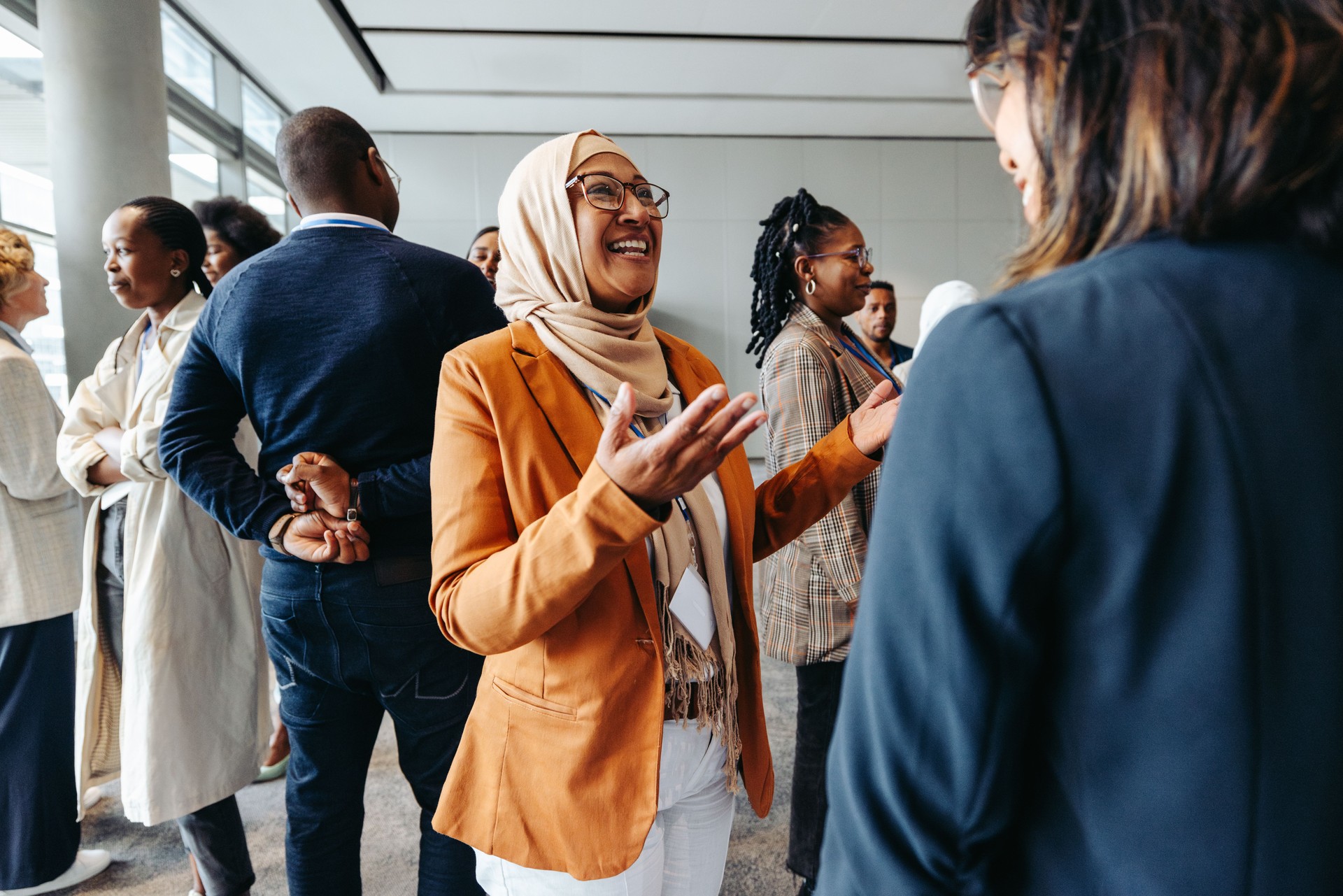 Femme d’affaires musulmane souriante partageant et parlant lors d’un événement de réseautage